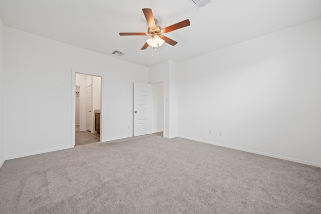 unfurnished bedroom featuring ensuite bath, baseboards, visible vents, and light carpet