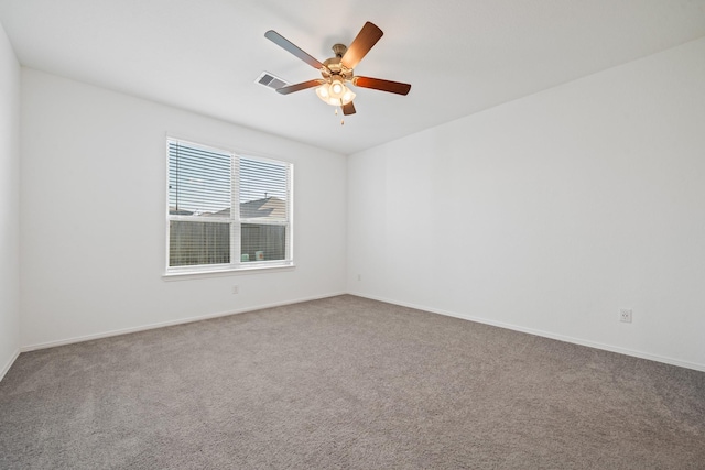 carpeted empty room featuring baseboards, visible vents, and ceiling fan