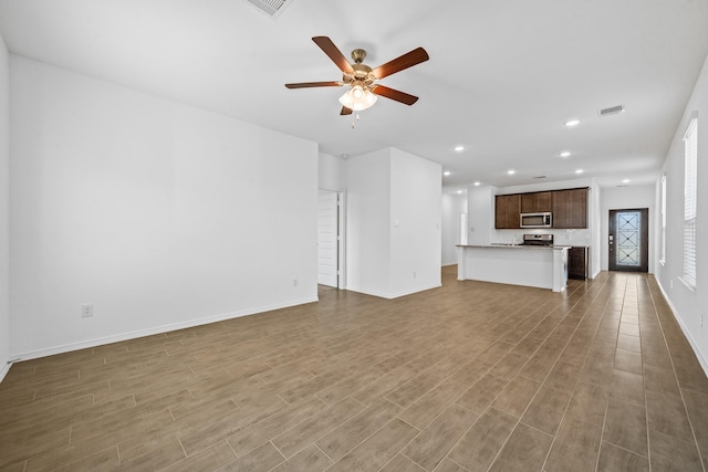 unfurnished living room featuring recessed lighting, wood finished floors, baseboards, and ceiling fan