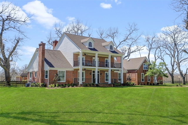 view of front of property featuring a porch, a balcony, a ceiling fan, and a front yard