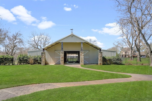 exterior space featuring a yard, an outdoor structure, a pole building, and fence