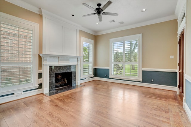 unfurnished living room featuring visible vents, ornamental molding, wood finished floors, a fireplace, and ceiling fan