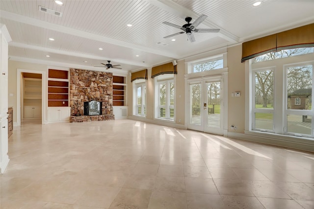 unfurnished living room featuring built in shelves, beamed ceiling, wood ceiling, a fireplace, and a ceiling fan