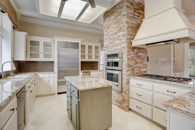 kitchen with backsplash, a kitchen island, appliances with stainless steel finishes, custom exhaust hood, and a sink