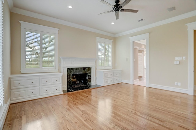 unfurnished living room featuring visible vents, light wood-style floors, crown molding, baseboards, and ceiling fan