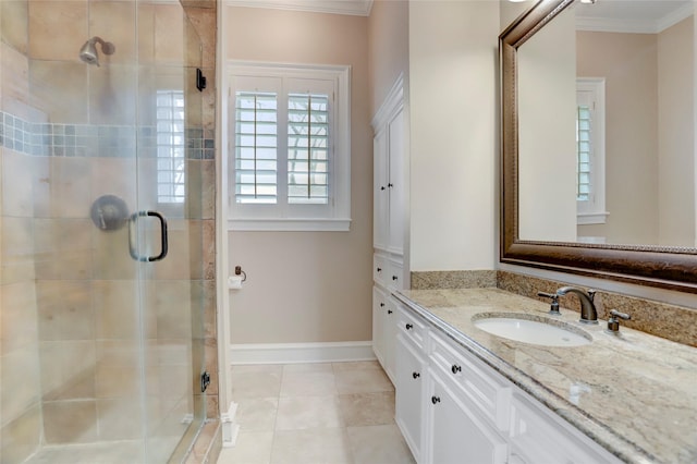 full bathroom featuring tile patterned flooring, crown molding, baseboards, a stall shower, and vanity