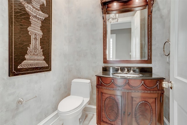 half bathroom with baseboards, toilet, and vanity