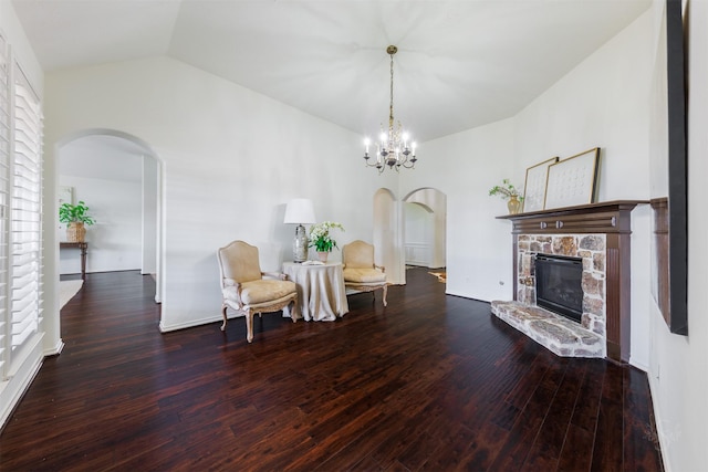 living area featuring a chandelier, arched walkways, lofted ceiling, and wood finished floors