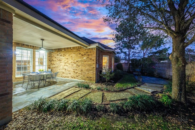 yard at dusk with a patio and fence