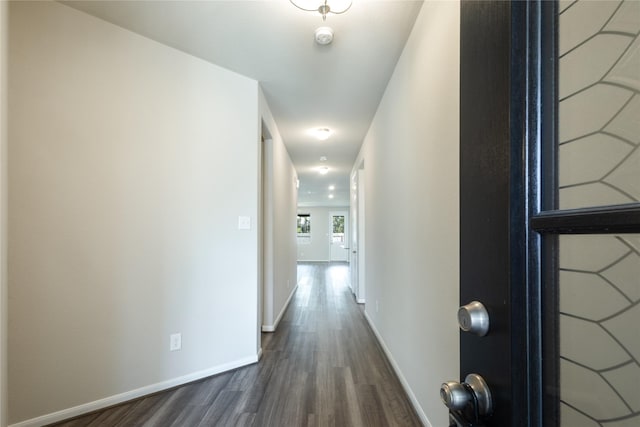 hall with baseboards and dark wood-style flooring