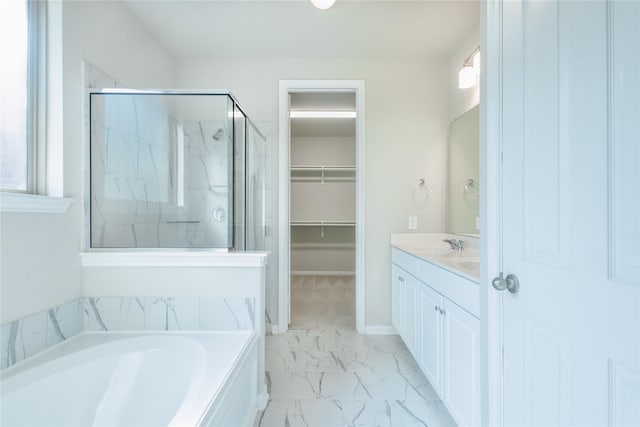 full bath featuring a marble finish shower, a spacious closet, a garden tub, marble finish floor, and vanity