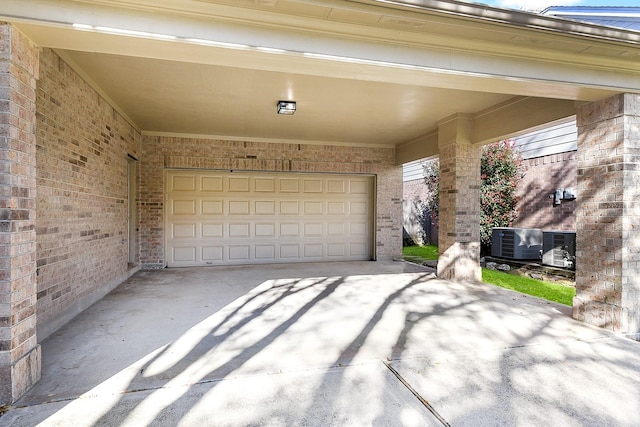 garage with central air condition unit and concrete driveway