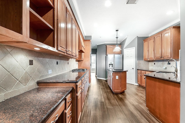 kitchen featuring a kitchen island, dark wood-type flooring, ornamental molding, stainless steel appliances, and a sink