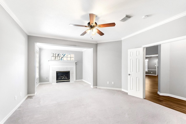 unfurnished living room featuring visible vents, baseboards, ceiling fan, and a tiled fireplace