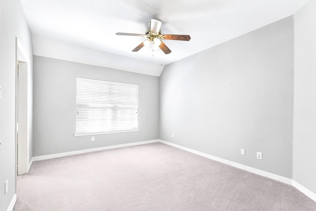 carpeted empty room with baseboards, ceiling fan, and vaulted ceiling