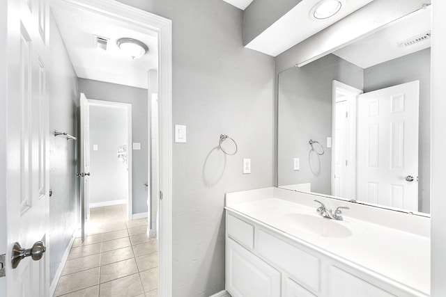 bathroom featuring vanity, baseboards, visible vents, and tile patterned flooring