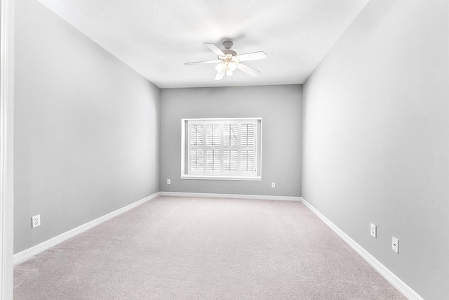 empty room with a textured ceiling, baseboards, ceiling fan, and carpet floors