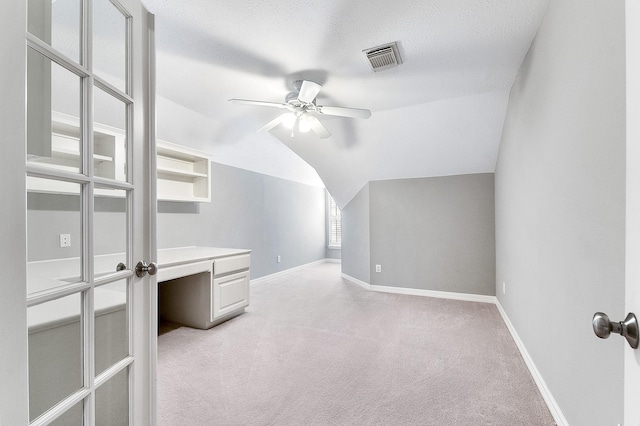 bonus room with visible vents, light carpet, a ceiling fan, baseboards, and vaulted ceiling