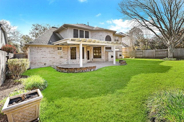 back of property with a pergola, a fenced backyard, a yard, brick siding, and a patio area