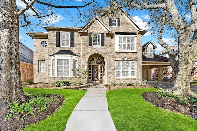 traditional home featuring brick siding and a front yard