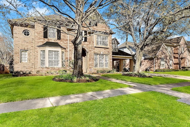 view of front of house featuring brick siding and a front lawn