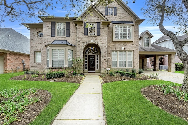 traditional-style home with driveway, brick siding, and a front lawn