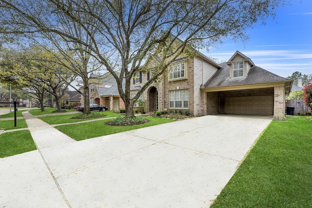 traditional-style house featuring brick siding, a garage, driveway, and a front yard