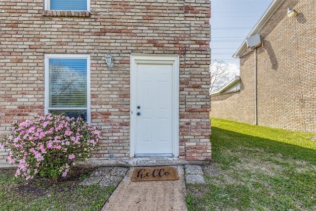 entrance to property featuring brick siding