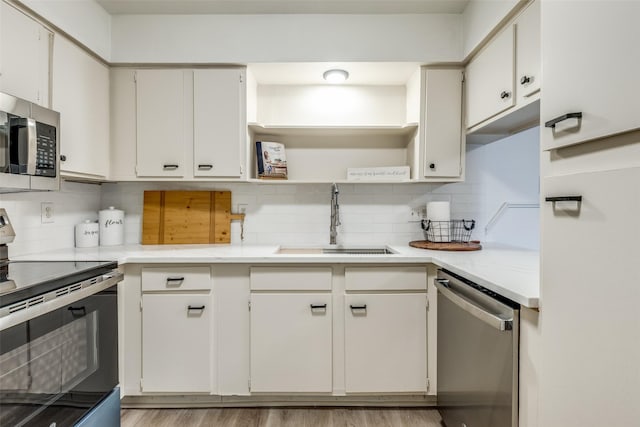 kitchen with tasteful backsplash, a sink, light countertops, stainless steel appliances, and open shelves