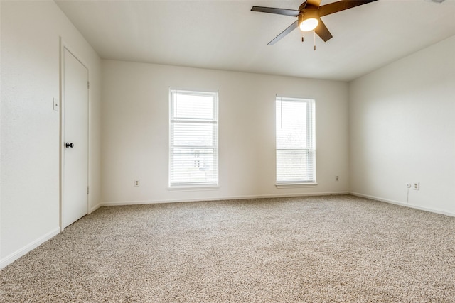 empty room featuring light carpet, baseboards, and a ceiling fan