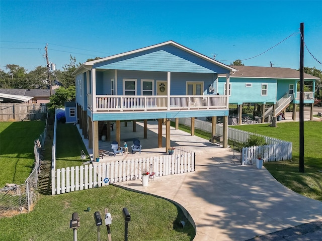 108 Bay Oaks Dr, La Porte, TX 77571 - raised beach house featuring a front yard, driveway, a fenced backyard, a carport, and a patio area