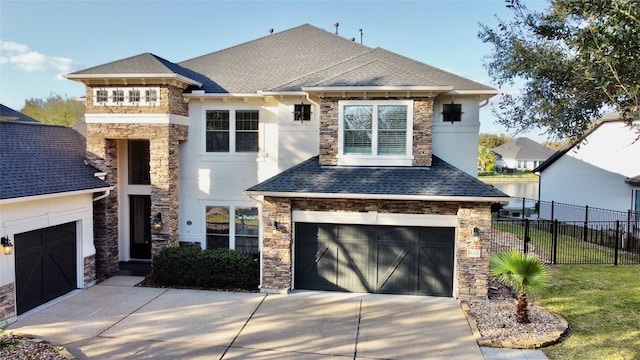 view of front of home featuring driveway, a shingled roof, a garage, and fence