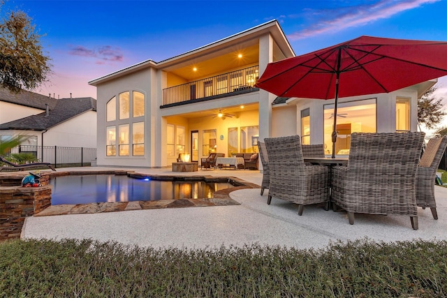 rear view of property with a patio, a balcony, a fenced in pool, and stucco siding