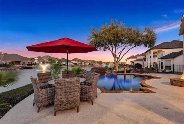 pool at dusk featuring outdoor dining space, a patio, fence, an outdoor pool, and a residential view