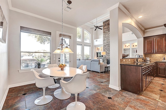 dining space featuring visible vents, stone finish flooring, baseboards, and ornamental molding