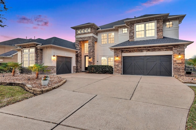 prairie-style home featuring a shingled roof, concrete driveway, stucco siding, a garage, and stone siding