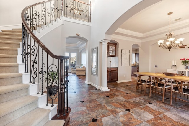 foyer entrance with a tray ceiling, visible vents, ornamental molding, and stairway