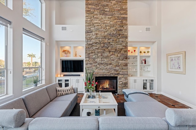 living room with built in features, visible vents, and plenty of natural light