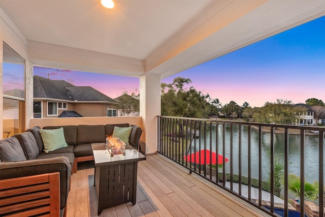 deck featuring an outdoor living space with a fire pit and a water view