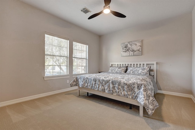 carpeted bedroom with visible vents, baseboards, and ceiling fan