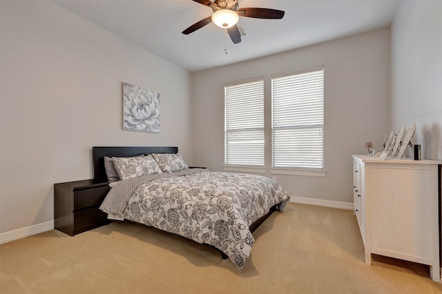 bedroom with a ceiling fan, baseboards, and light carpet