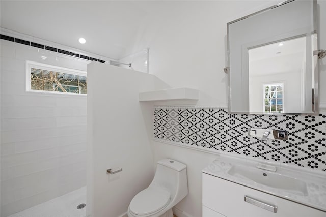 bathroom featuring vanity, toilet, recessed lighting, and tiled shower