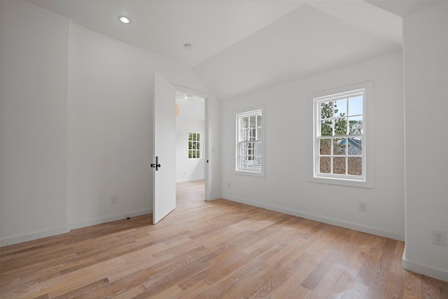 spare room with recessed lighting, light wood-type flooring, baseboards, and vaulted ceiling