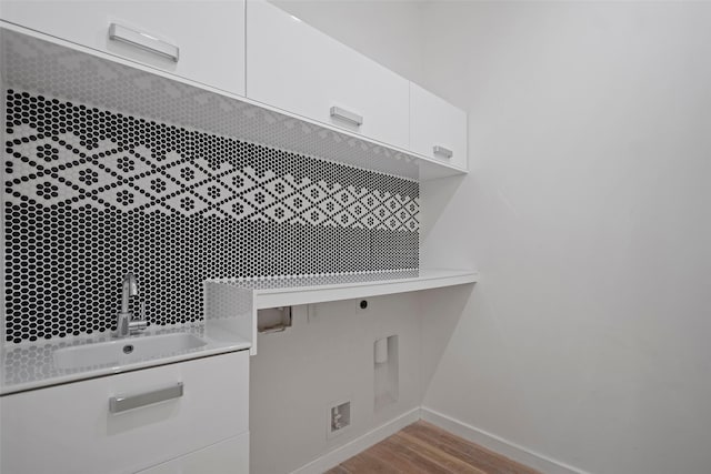 laundry area with washer hookup, wood finished floors, cabinet space, electric dryer hookup, and a sink