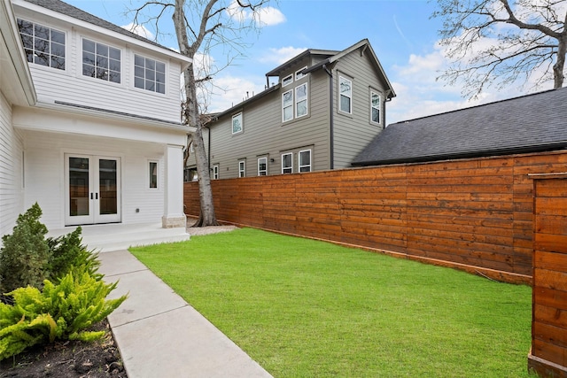 view of yard with french doors and fence