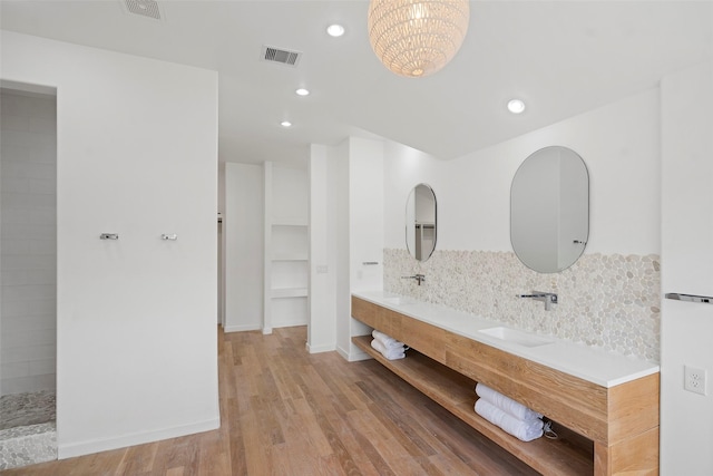 full bathroom with visible vents, a sink, backsplash, wood finished floors, and recessed lighting