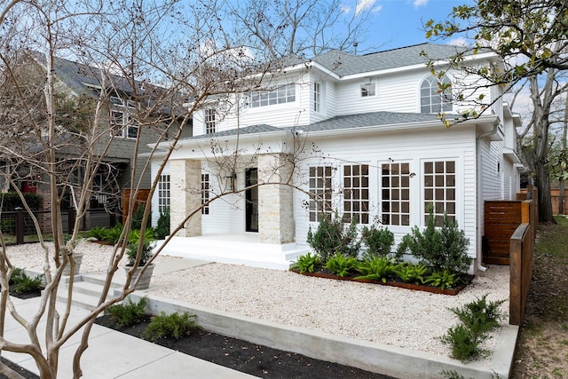 traditional-style home with roof with shingles and fence