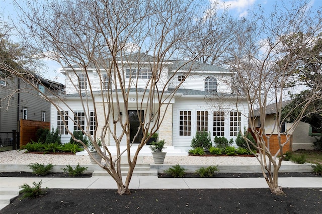 traditional-style home featuring roof with shingles