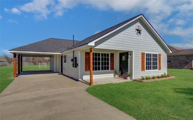 view of front of property featuring concrete driveway, a shingled roof, a front yard, and fence