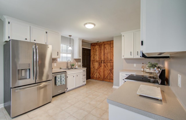 kitchen with appliances with stainless steel finishes, white cabinetry, and a sink